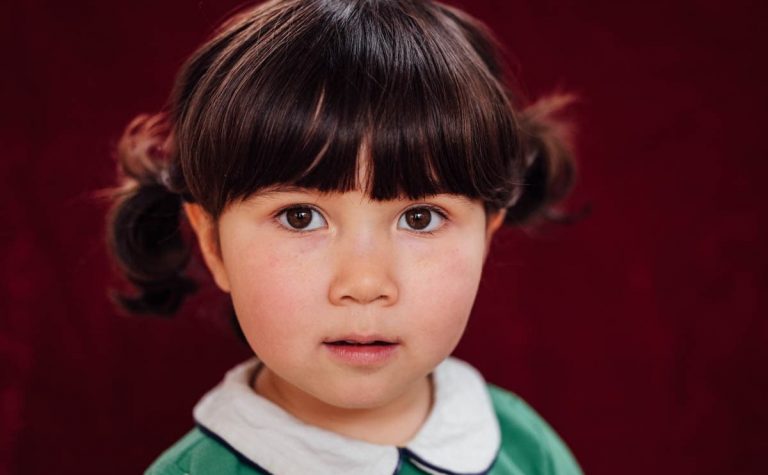 Girl with bunchies and green top and white collar