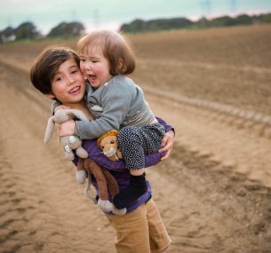 Boy carrying girl in field