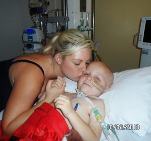 mum kissing son Blake by hospital bed