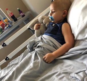 Boy in hospital bed with bunny toy