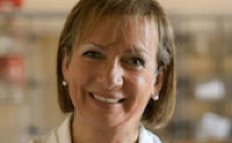 female researcher in white lab coat smiling at camera fiorella belpoggi