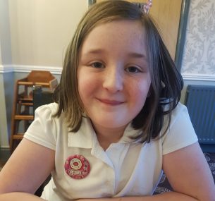 Girl in white polo shirt and birthday badge