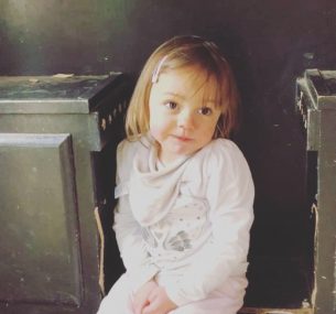 young girl sitting down smiling