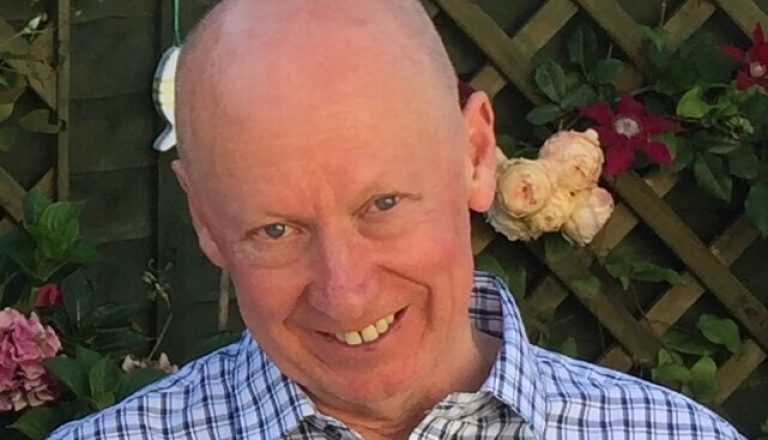 Mike Hawkins man wearing blue and white stripped shirt smiling at camera