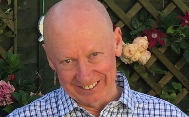 Mike Hawkins man wearing blue and white stripped shirt smiling at camera