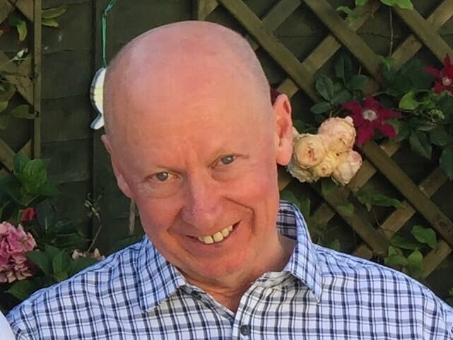 Mike Hawkins man wearing blue and white stripped shirt smiling at camera