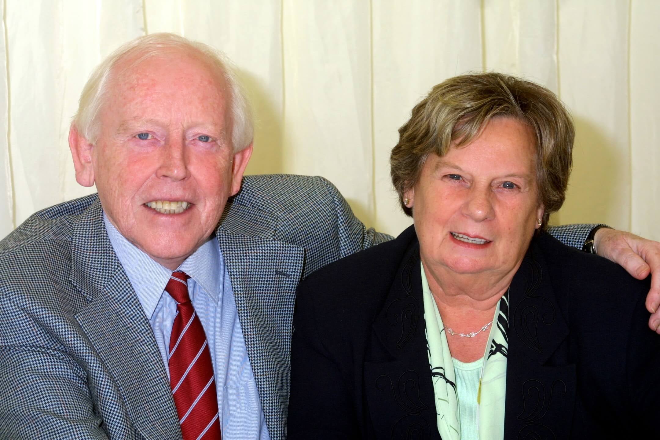 Eddie and Marion sitting together smiling at camera. min