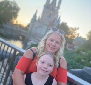 Mother and daughter standing in front of Disney castle