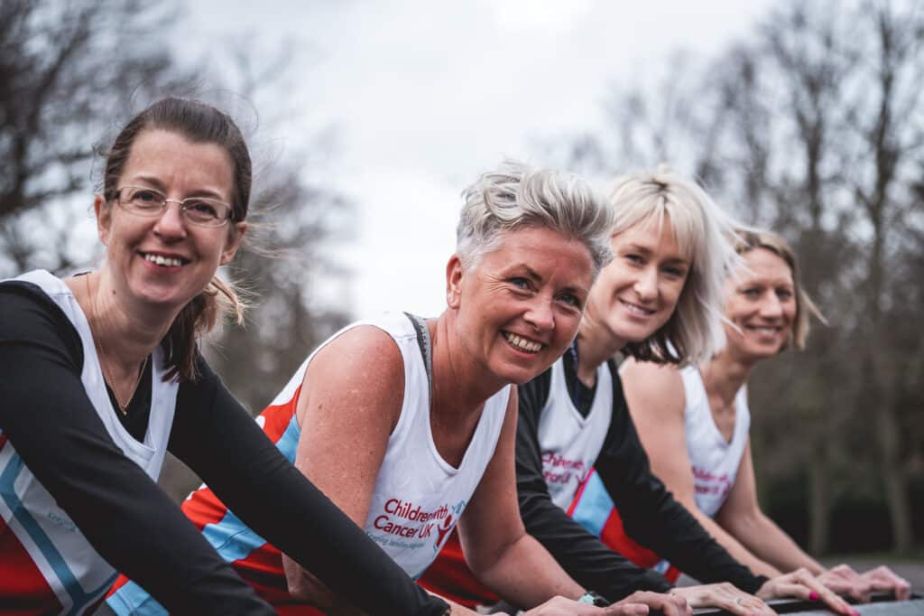 four marathon mums wearing vests smiling looking at camera