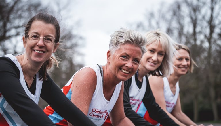 four marathon mums wearing vests smiling looking at camera