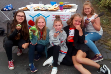 girls fundraising with money collection box and table