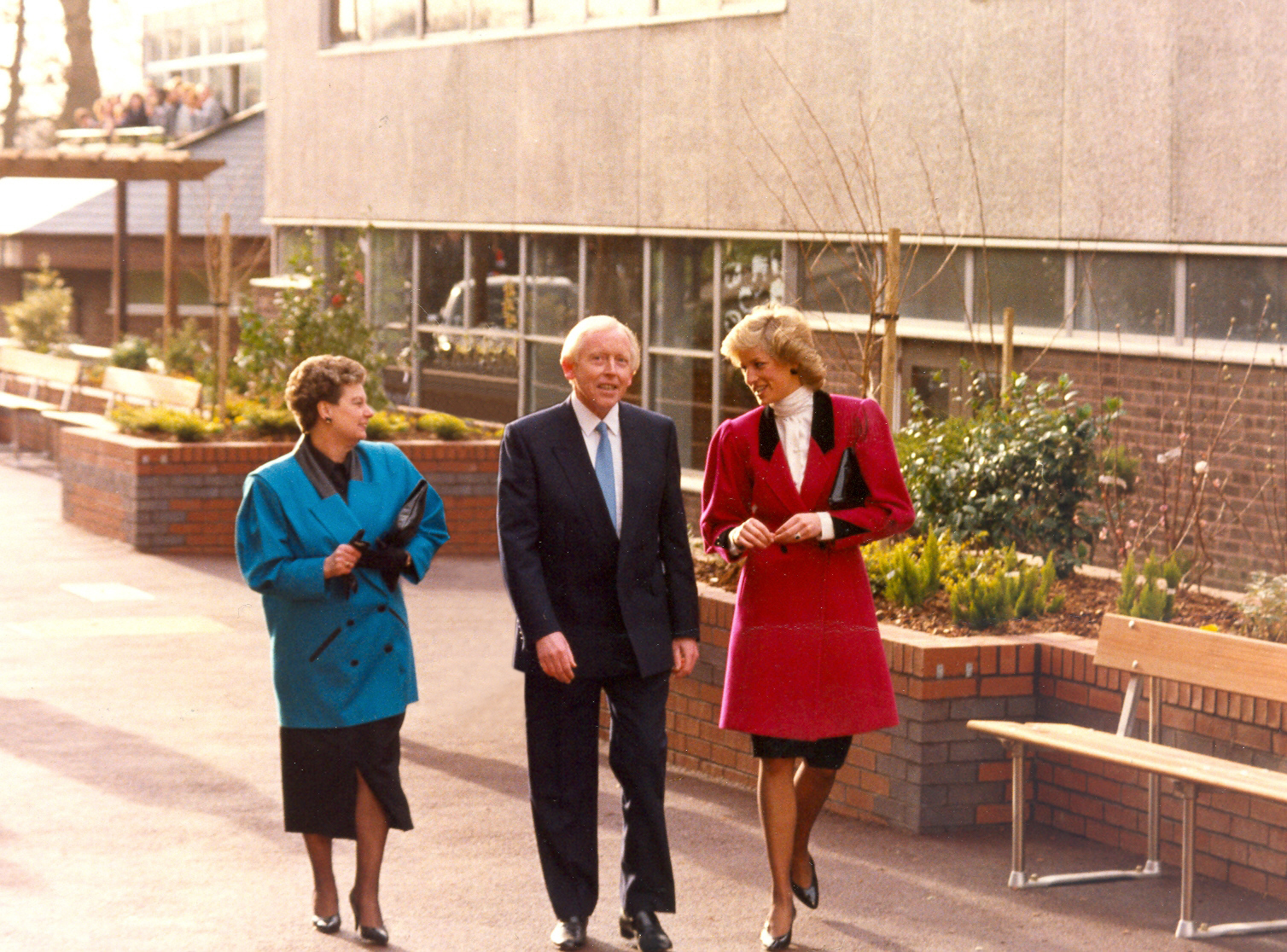 Princess Diana walking wearing a red coat with Marion and Eddie OGorman