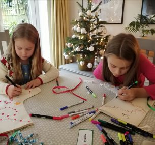 suki and sister sitting at table colouring in for christmas activities