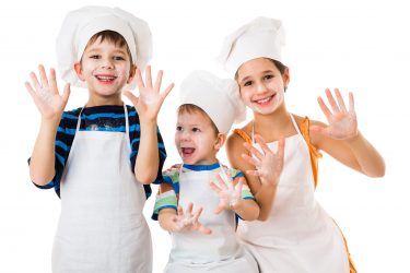 Children Baking wearing white chef hats and apron
