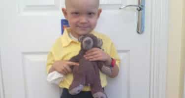 Harry on his First Day Of School in a yellow tshirt holding teddy 1