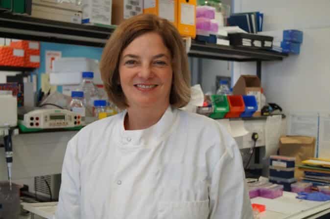 julie irving female researcher wearing white lab coat