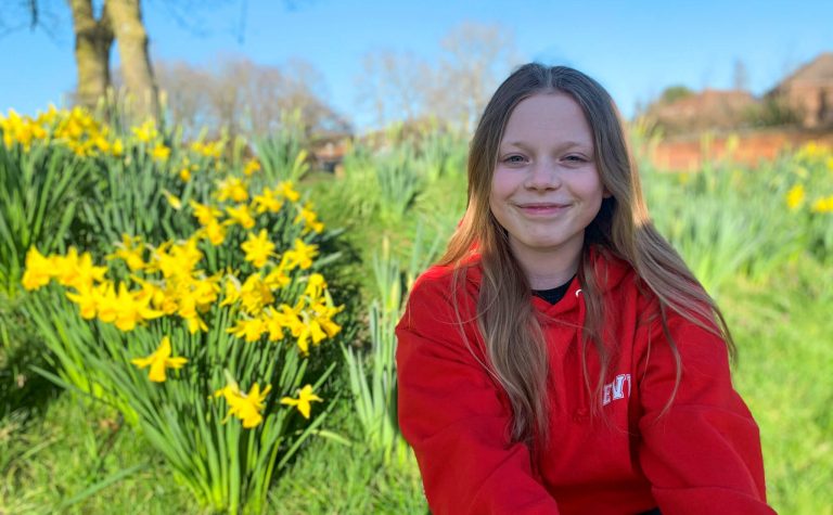 Eve sitting in park with daffodils