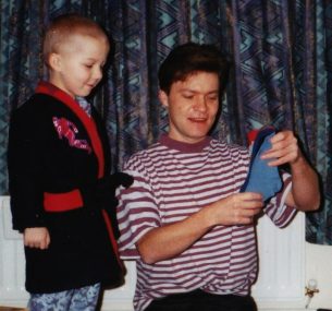 christopher with his dad looking a a pair of socks at christmas