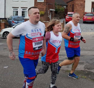 Jess running with two men in charity vests