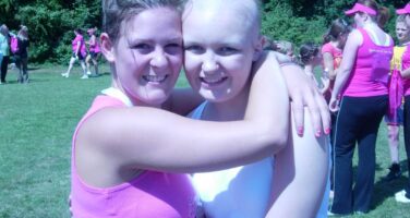 chloe with no hair hugging friend