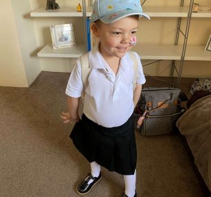 Isla in nursery uniform with cap