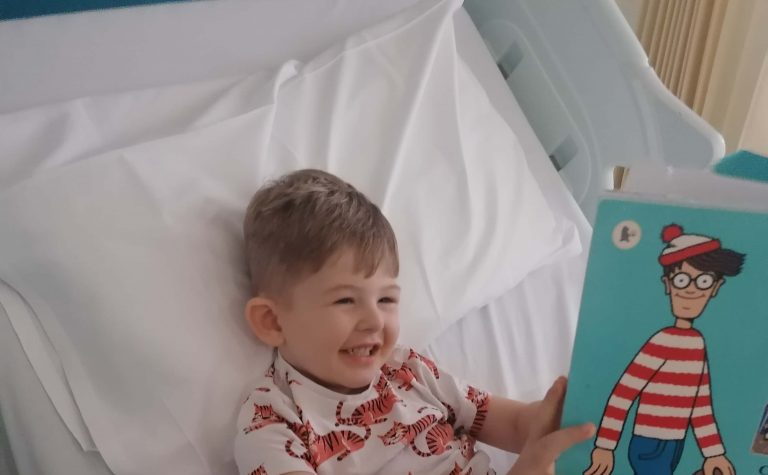 Finley in hospital bed readin wheres wally