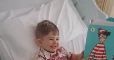 Finley in hospital bed readin wheres wally