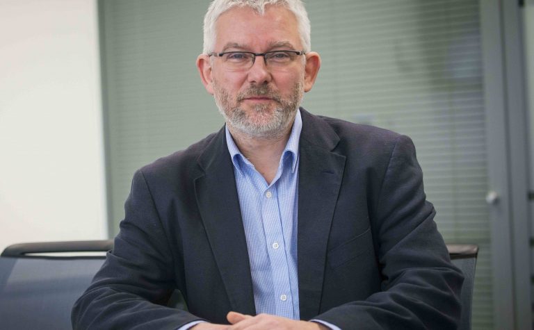 Steve Clifford male researcher wearing glasses sitting at desk looking at camera..