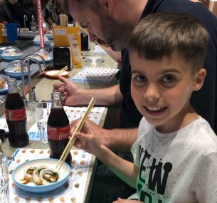 Alfie in a restaurant eating sushi