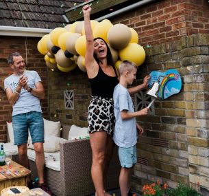 Lenny and parents with yellow balloons