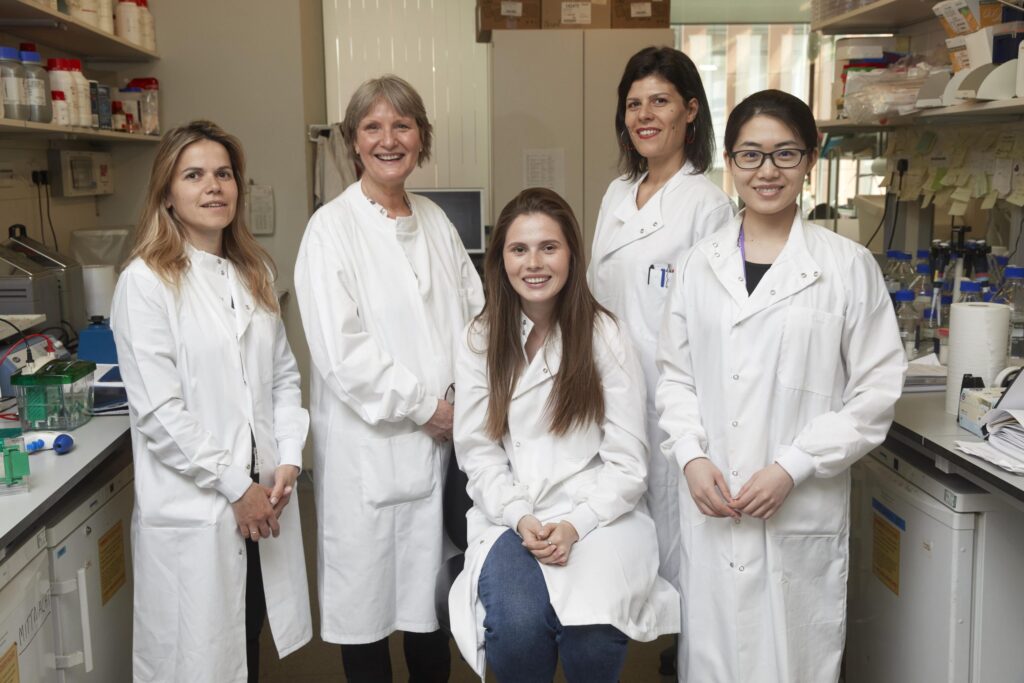 five female researchers wearing white lab coats