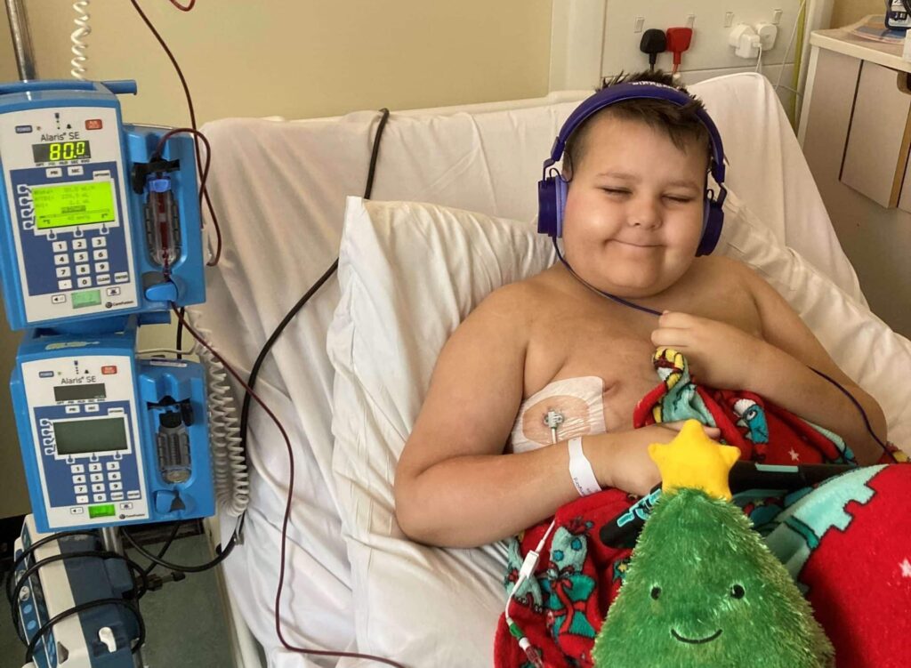 Jesse in hospital bed having a blood transfusion during Christmas