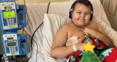 Jesse in hospital bed having a blood transfusion during Christmas