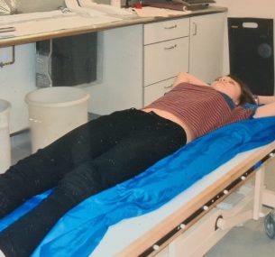 Leah laying down being fitted in radiotherapy bag