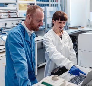 Two researchers looking at a laptop screen