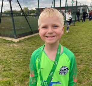 Dylan in football outfit with medal