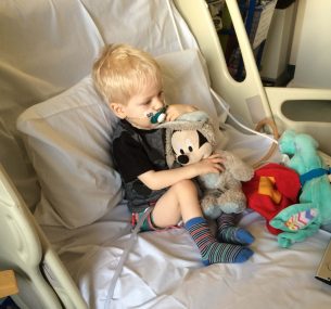 Dylan in hospital bed with mickey mouse