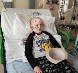 Stanley laying down in hospital bed with tubes