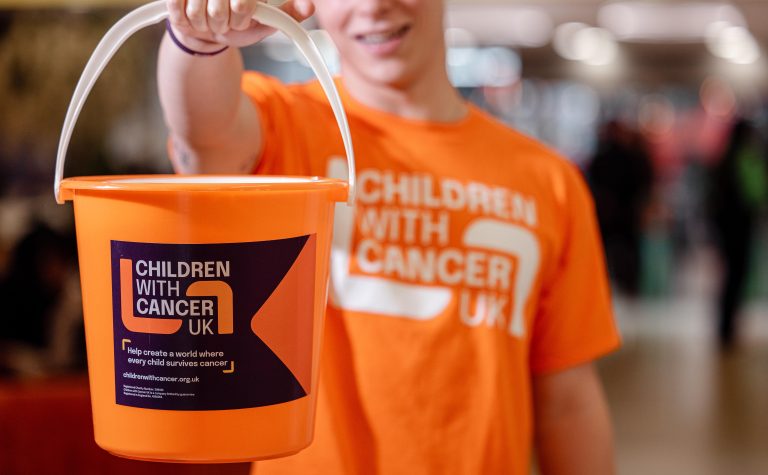 man holding a collection bucket in orange t shirt