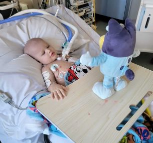 Archer in hospital bed with toy