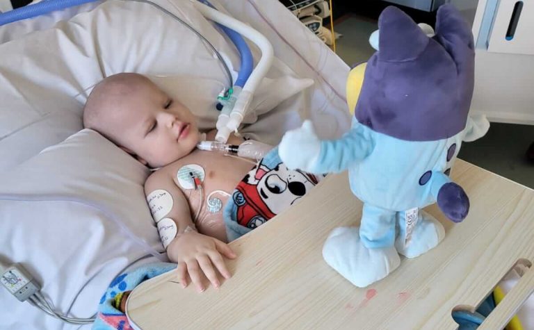 Archer in hospital bed with toy
