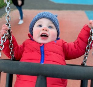 Mason in red coat on swing