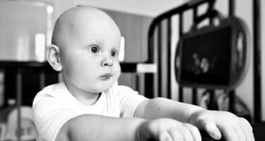 Mason looking off camera in crib, black and white