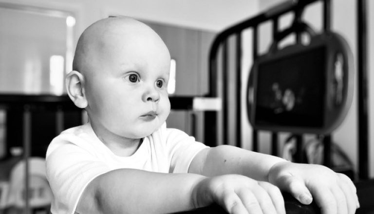 Mason looking off camera in crib, black and white