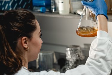 Female researcher looking at flask