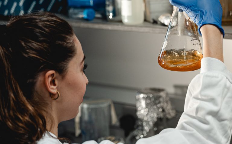 Female researcher looking at flask