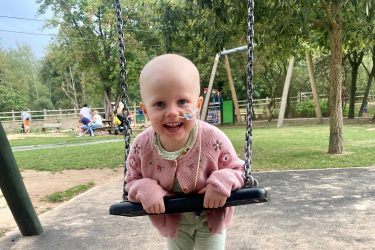 Matilda with nose tube on playground swing webpage