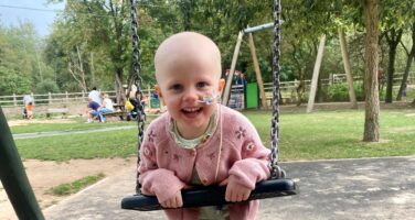 Matilda with nose tube on playground swing webpage