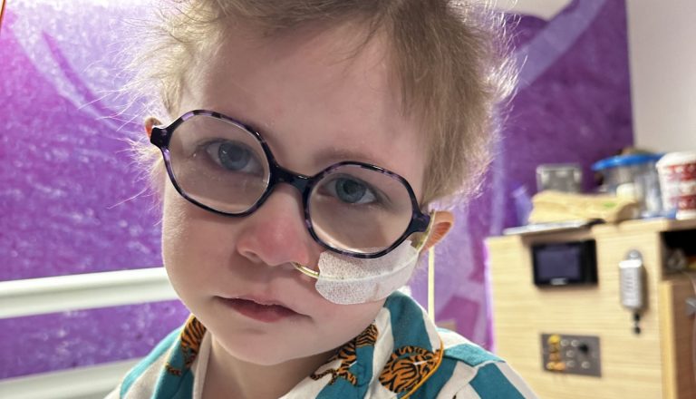 Dulcie in hospital bed with tube up her nose.