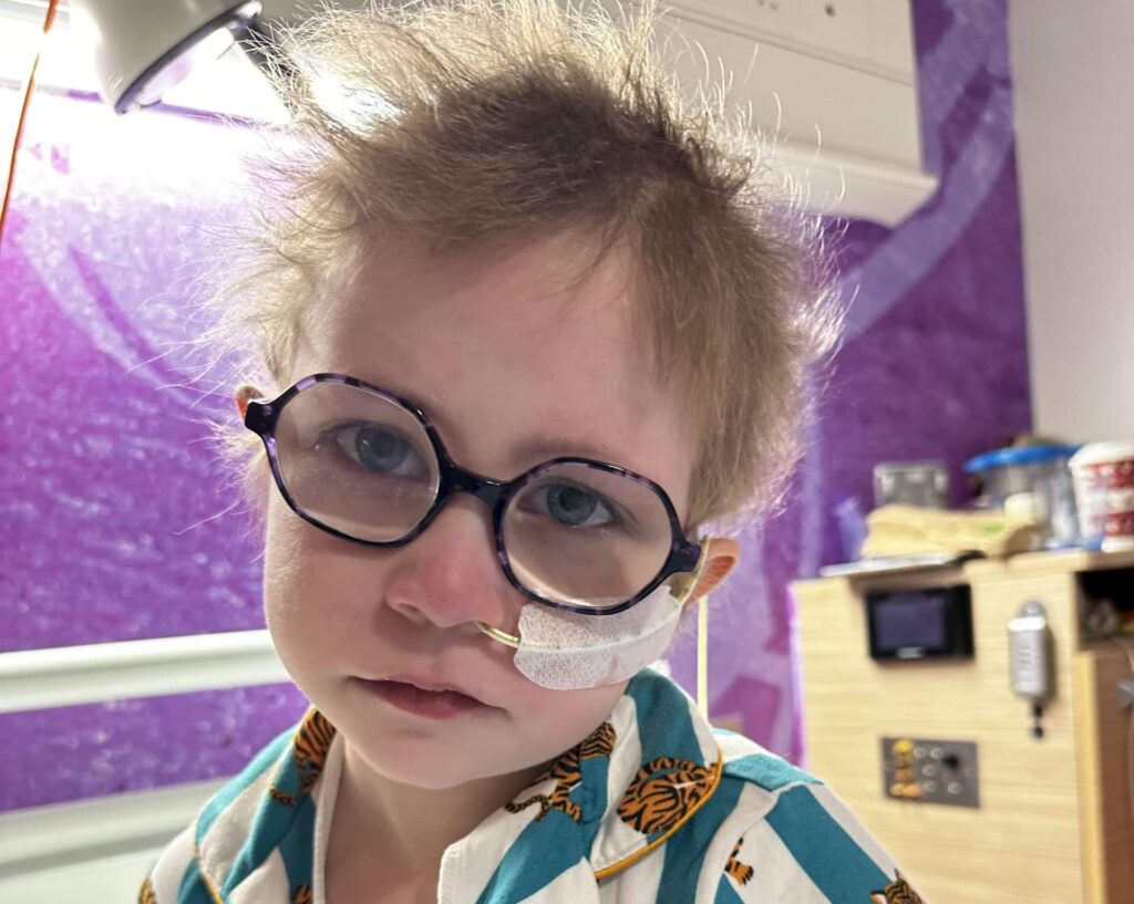 Dulcie in hospital bed with tube up her nose.